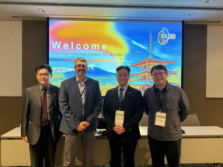 好晴天身心診所藍祚鴻醫師（右一）於2025年ISBD國際雙極性疾患學會年度大會，與國際學者合影留念，背景為日本千葉大會歡迎看板